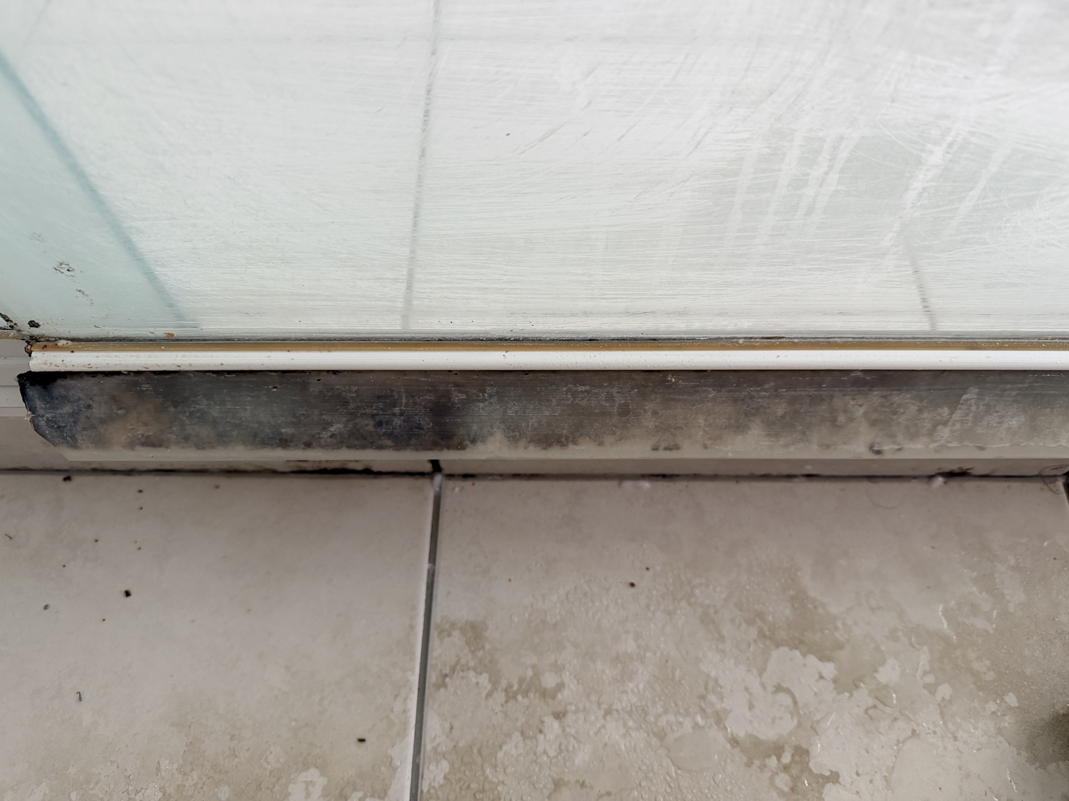Before: close-up of build-up around the shower screen base. Hope Island spring cleaning by Cleankill